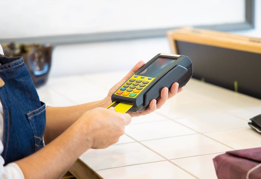 A card being inserted into a handheld payment terminal