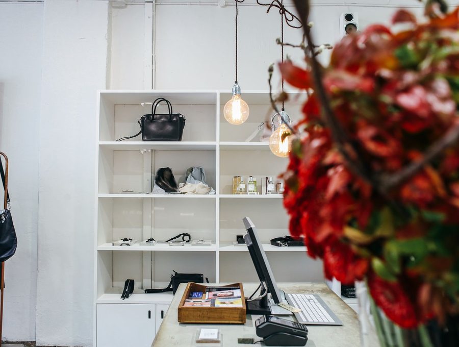 A shop counter with a card terminal and shelving behind