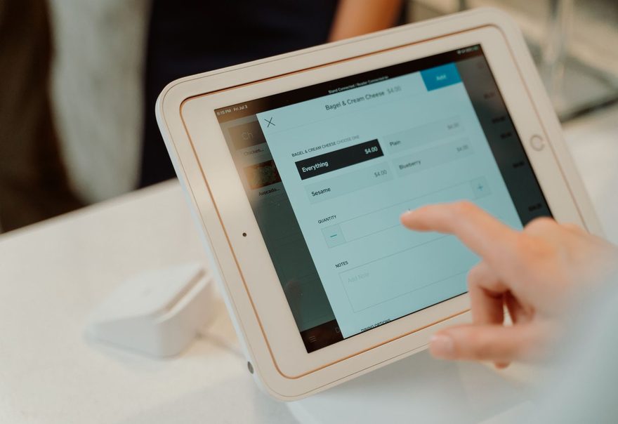 A tablet point-of-sale system on a stand being tapped