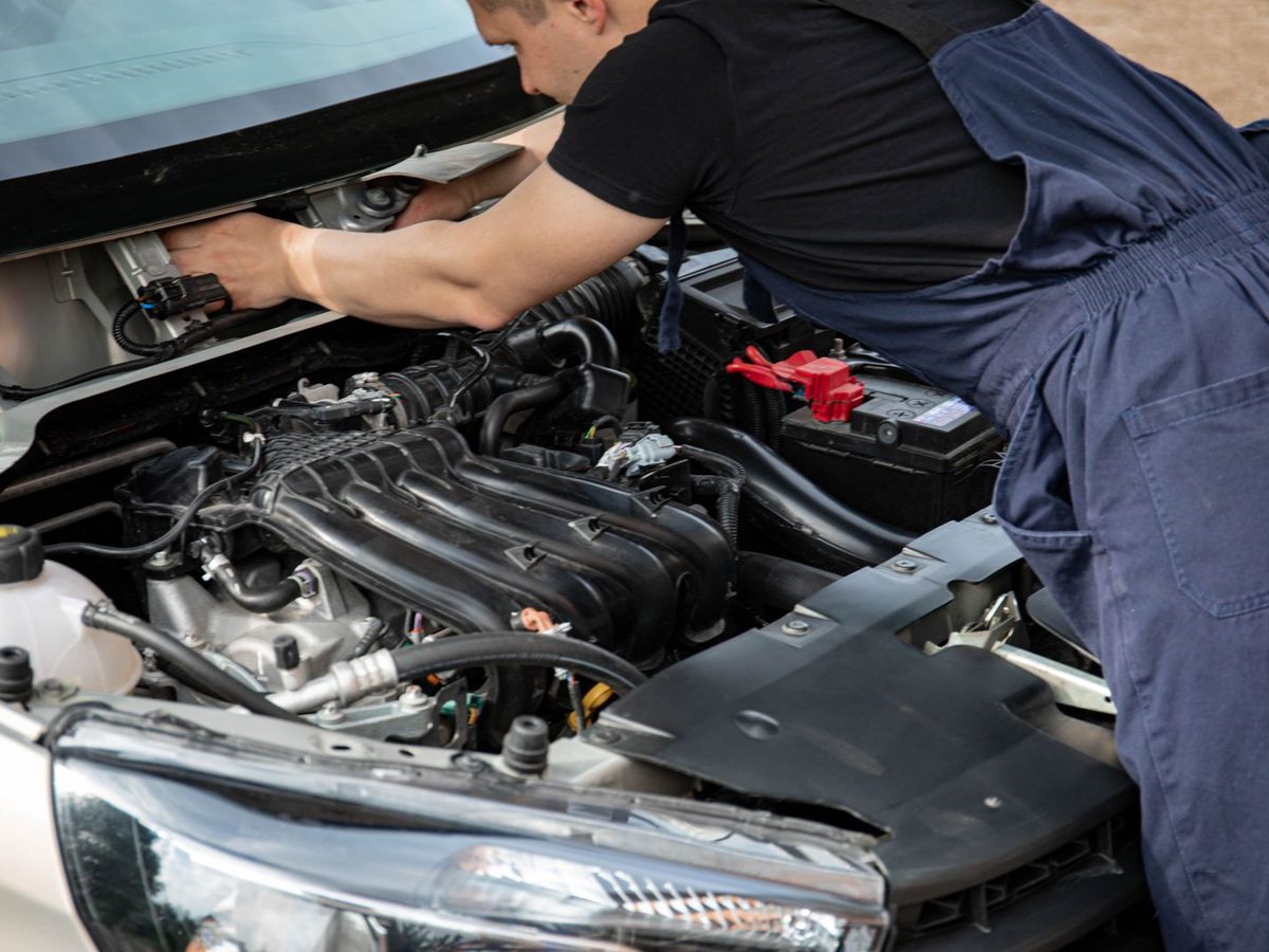 A technician working in an open engine bay