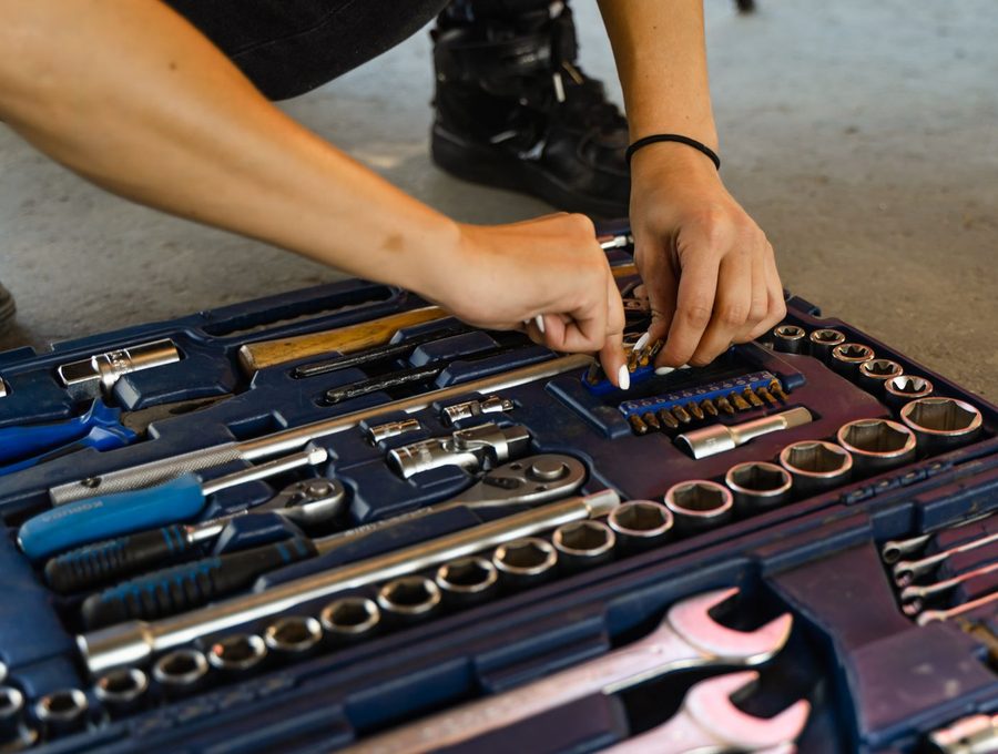 A hand selecting a socket from an open tool case